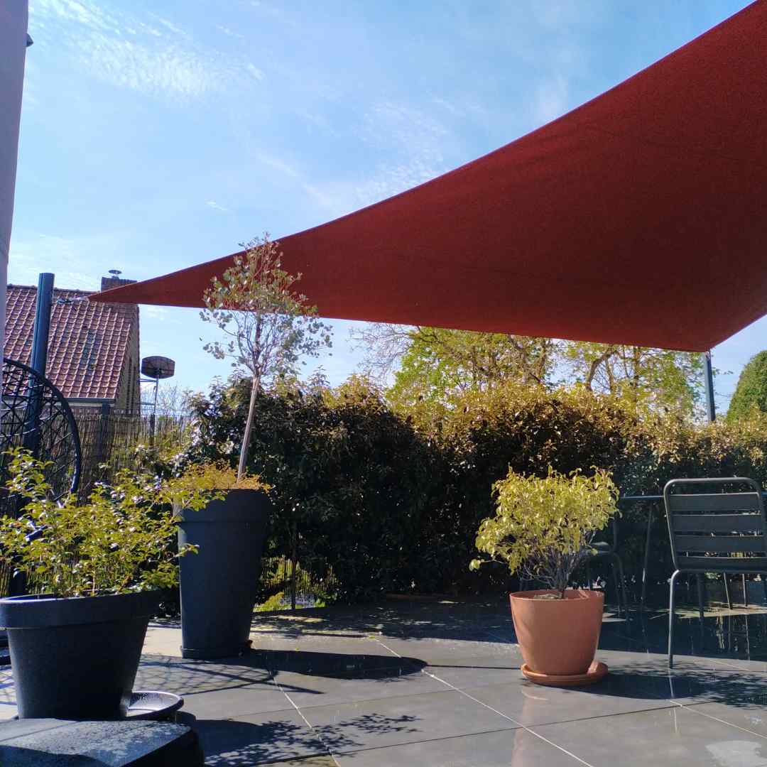 Voile d’ombrage imperméable rouge au dessus d’une terrasse