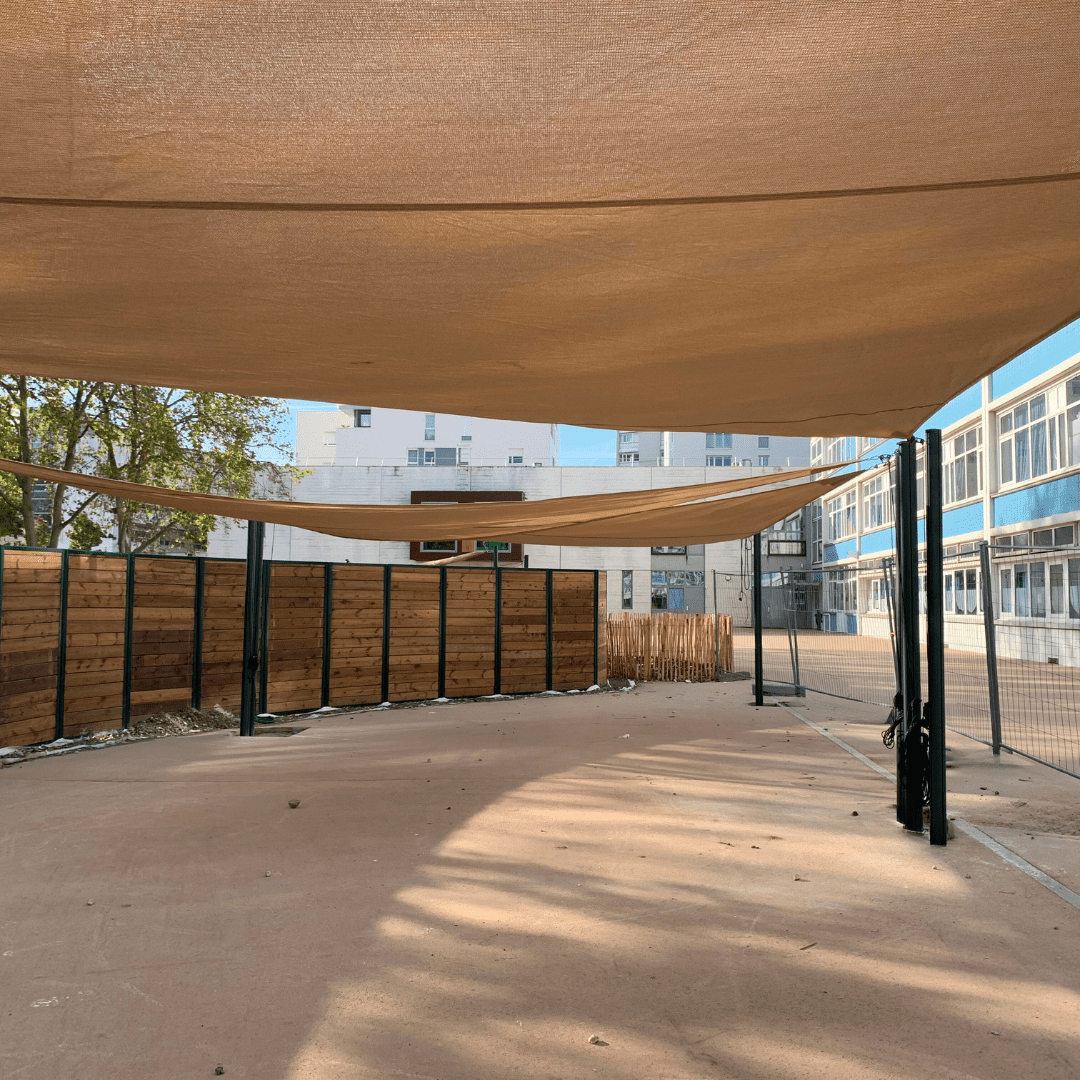 Voile ombrage ajourée avec enrouleur manuel dans une école