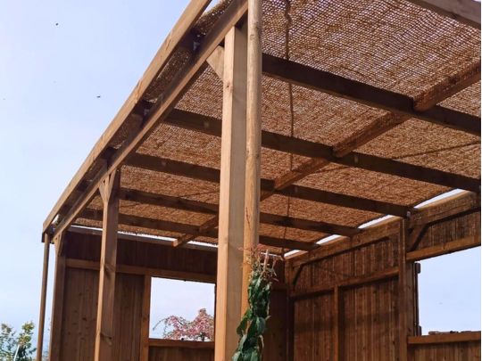 Toile ombrage pergola en coco posée sur structure bois